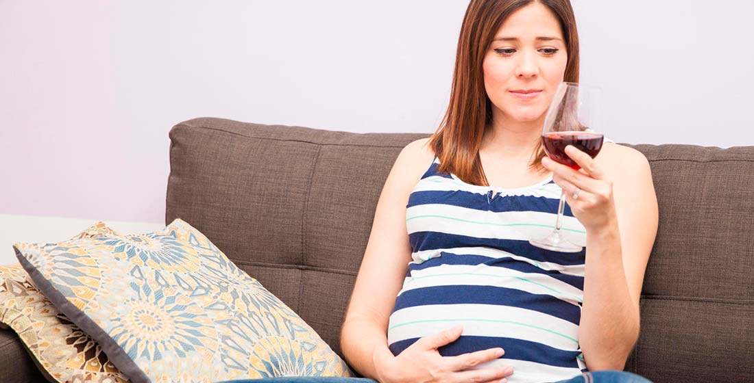 беременная женщина с бокалом вина в руке