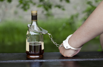 Бутылка и рука скреплены наручниками